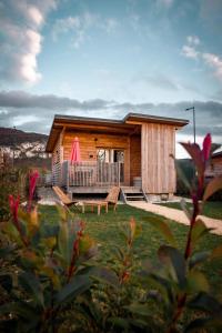 eine Blockhütte mit einer Veranda und einer Terrasse in der Unterkunft Les Lodges de la ViaRhôna / cabane-spa in Virignin