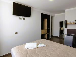 a bedroom with a bed with two towels on it at Tierra del Sol Centro in Moquegua