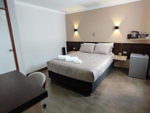 1 dormitorio con 1 cama con 2 toallas en Tierra del Sol Centro, en Moquegua