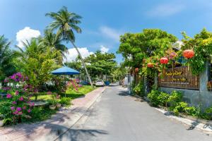 uma rua vazia com flores e uma cerca em Sands River Hoi An Villa em Hoi An