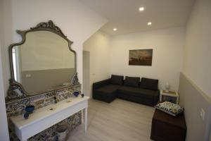 sala de estar con espejo y sofá en Modica Balcony en Modica