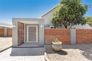 a house with a brick wall and a door at La Montagne Lodge in Riebeek-Kasteel