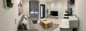 - un salon avec un canapé et une télévision dans l'établissement Maylou07, à Montauban