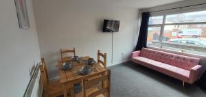 salon z różową kanapą i stołem w obiekcie Stoke City House w mieście Etruria