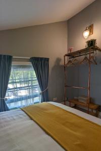 a bedroom with a bed with blue curtains and a window at Banks Bed & Continental Breakfast in Minster