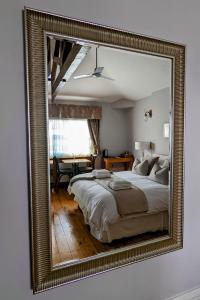 a mirror reflecting a bedroom with a large bed at Banks Bed & Continental Breakfast in Minster