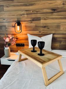 - un plateau en bois avec 2 verres à vin sur le lit dans l'établissement Exclusive apartment Новобудова ЖК Театральний ЦЕНТР, à Rivne