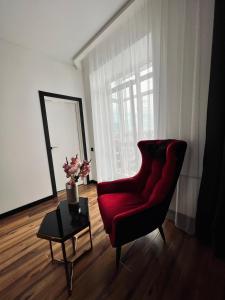 a living room with a red chair and a table at Exclusive apartment Новобудова ЖК Театральний ЦЕНТР in Rivne