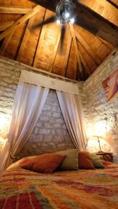 a bed in a room with a wooden ceiling at Domaine Les Miquels in Castelnau-de-Montmiral