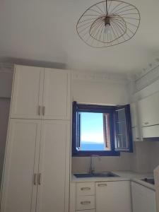 a kitchen with a window and a sink and a light at La mer in Gythio