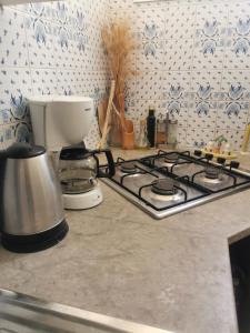 a kitchen counter with a stove top with a coffee pot at Écrin in Sousse