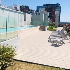 uma piscina no telhado de um edifício com um banco em Edificio fresh pampa em Buenos Aires