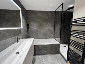 a bathroom with a tub and a sink at POLARIS Bel appartement village et pistes in La Clusaz +13 photos