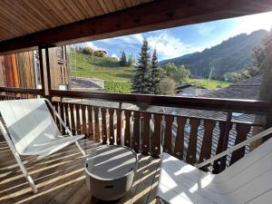 a white chair sitting on a wooden balcony with a view at POLARIS Bel appartement village et pistes in La Clusaz