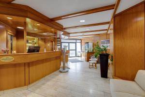 an office lobby with a reception desk and wooden walls at Hotel Schomacker in Lilienthal