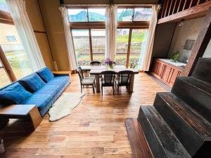 sala de estar con sofá azul y mesa en 古民家宿Tani House Itaya -セルフチェックイン en Tokamachi