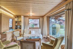 uma sala de estar com cadeiras, uma mesa e uma janela em Appartement Lanura - Welkeys em Megève