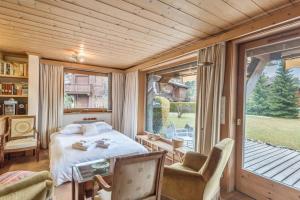 um quarto com uma cama e uma grande janela em Appartement Lanura - Welkeys em Megève