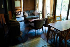 sala de estar con estufa de leña y mesa en 古民家宿Tani House Itaya -セルフチェックイン en Tokamachi