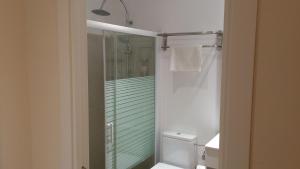 バルセロナにあるホスタル バルセロナ トラベルのトイレとガラスのシャワー付きのバスルーム +33枚の写真