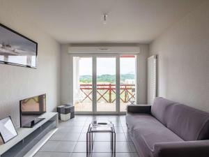 sala de estar con sofá y ventana grande en Appartement Hendaye, 2 pièces, 4 personnes - FR-1-2-308, en Hendaya