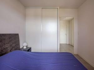 a bedroom with a purple bed and a closet at Appartement Hendaye, 2 pièces, 4 personnes - FR-1-2-308 in Hendaye