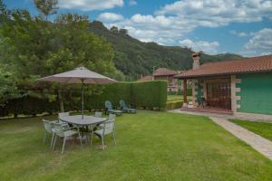 a table and chairs with an umbrella in a yard at El rincón de Lalo in Prases