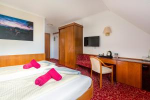 a hotel room with a bed and a desk at Hotel Schomacker in Lilienthal