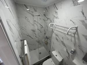 a bathroom with a shower and a marble wall at Lisbon Ocean Apartments in Costa da Caparica