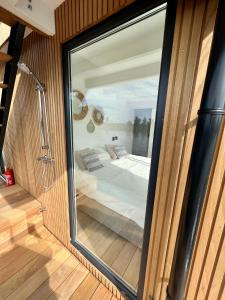 Surla houseboat "Aqua Zen" Kagerplassen with tender في Kaag: باب زجاجي يؤدي إلى غرفة نوم في منزل