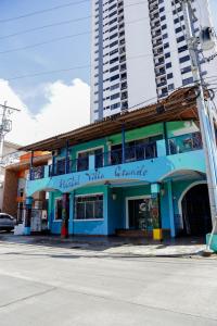 un edificio azul en una calle con un edificio alto en Hostal Villa Grande, en Panamá