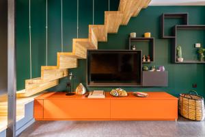 a living room with an orange cabinet and a staircase at Chambre D'hôtes Chez Dom in Saint-Jean-de-Maurienne