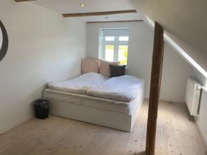 een klein bed in een kamer met een raam bij Brigsted B&B in Horsens