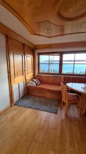 a room with a bench and a table and windows at Appartement Schwindelfrei in Niederndorferberg