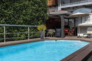 a large blue swimming pool next to a building at Chambre D'hôtes Chez Dom in Saint-Jean-de-Maurienne