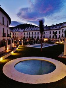 duży dziedziniec z dużym budynkiem i drzewem w obiekcie Velez Nazari w mieście Vélez de Benaudalla