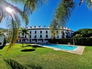 a large building with a swimming pool in front of it at Velez Nazari in Vélez de Benaudalla