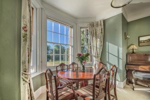 a dining room with a table and chairs and a window at Harkstead Hall By Group Retreats in Ipswich