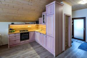 una cucina con armadi in legno e piano cottura. di Apartmán Elizabeth a Krahule