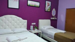 1 dormitorio con 2 camas y pared púrpura en Taman Negara River View Lodge en Kuala Tahan