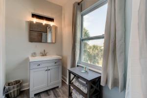 a bathroom with a sink and a window at 5 bed 4 bath pool table fire pit walk to beach in Daytona Beach +28 photos