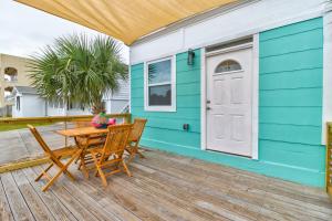 a blue house with a table and chairs on a deck at 5 bed 4 bath pool table fire pit walk to beach in Daytona Beach