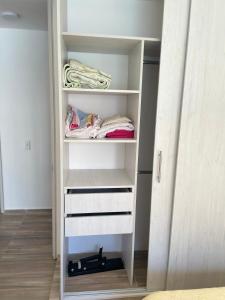 a closet with white drawers and white shelves at Apartahotel in Ibagué
