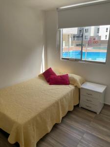 a bedroom with a bed and a window at Apartahotel in Ibagué