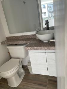 a bathroom with a toilet and a sink at Apartahotel in Ibagué +6 photos