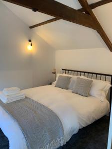 a bedroom with a bed with white sheets and pillows at The Old Chapel Manton 