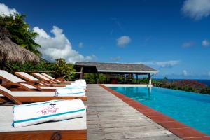 una fila di sedie a sdraio accanto alla piscina di Tet Rouge Resort a Soufriere Altre 25 foto