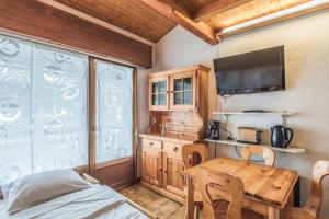 a dining room with a table and a tv at Charming flat with balcony at the foot of the slopes in Megève - Welkeys in Megève