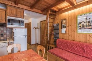 a kitchen and living room in a log cabin at Charming flat with balcony at the foot of the slopes in Megève - Welkeys in Megève