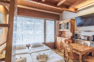 ムジェーヴにあるCharming flat with balcony at the foot of the slopes in Megève - Welkeysのベッド3台、テーブル、窓が備わる客室です。